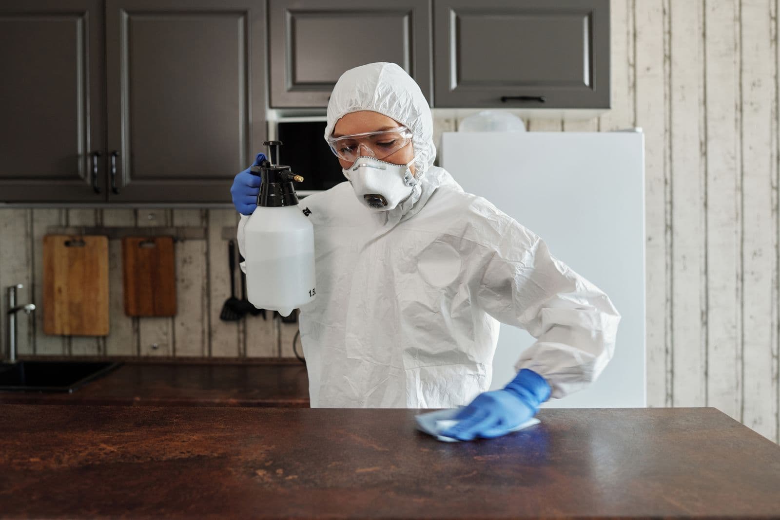 Désinfection d'un plan de travail en combinaison et gants