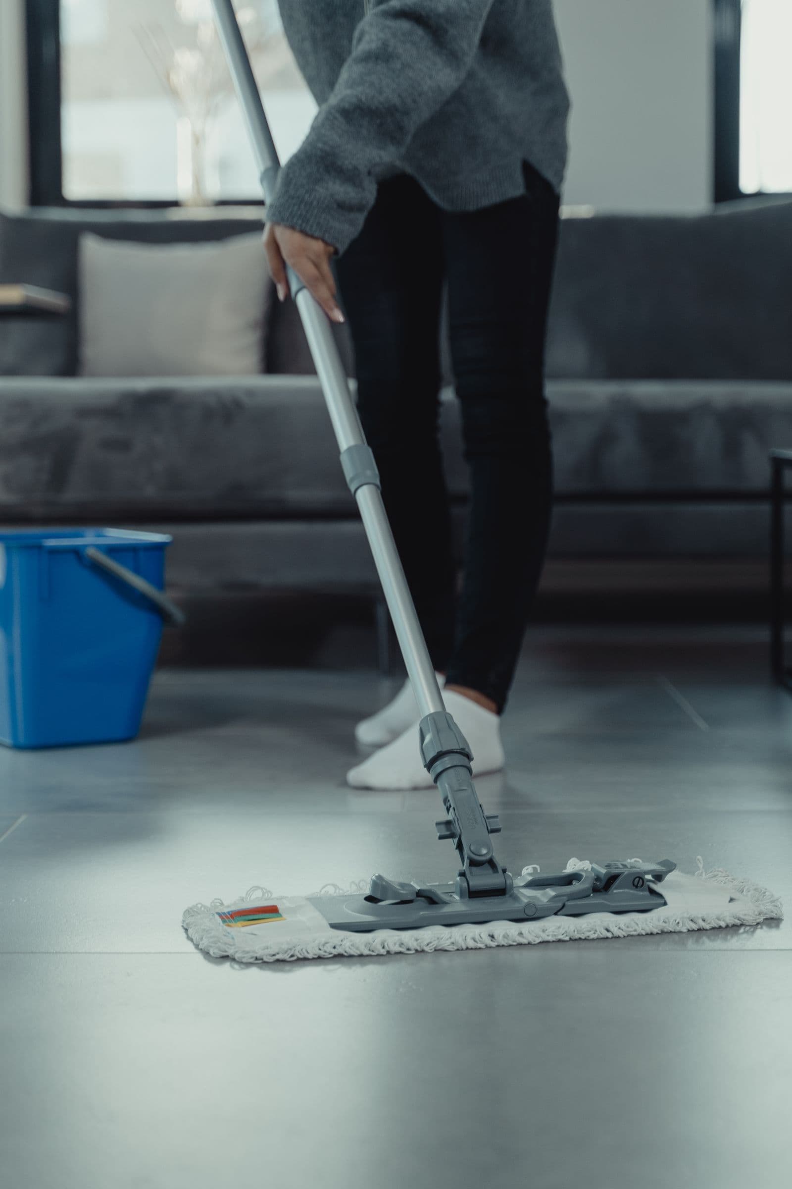 Lavage d'un sol de séjour au balai à franges, seau de service à côté