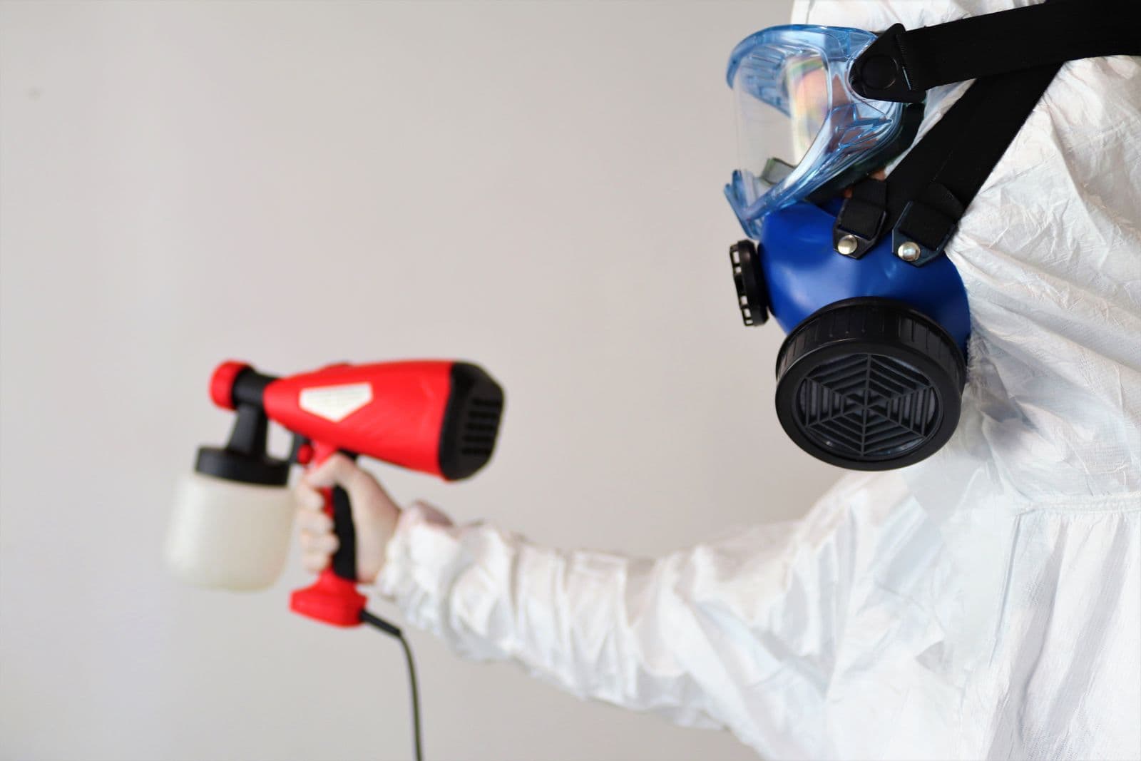 Pulvérisation d'un désinfectant en tenue de protection