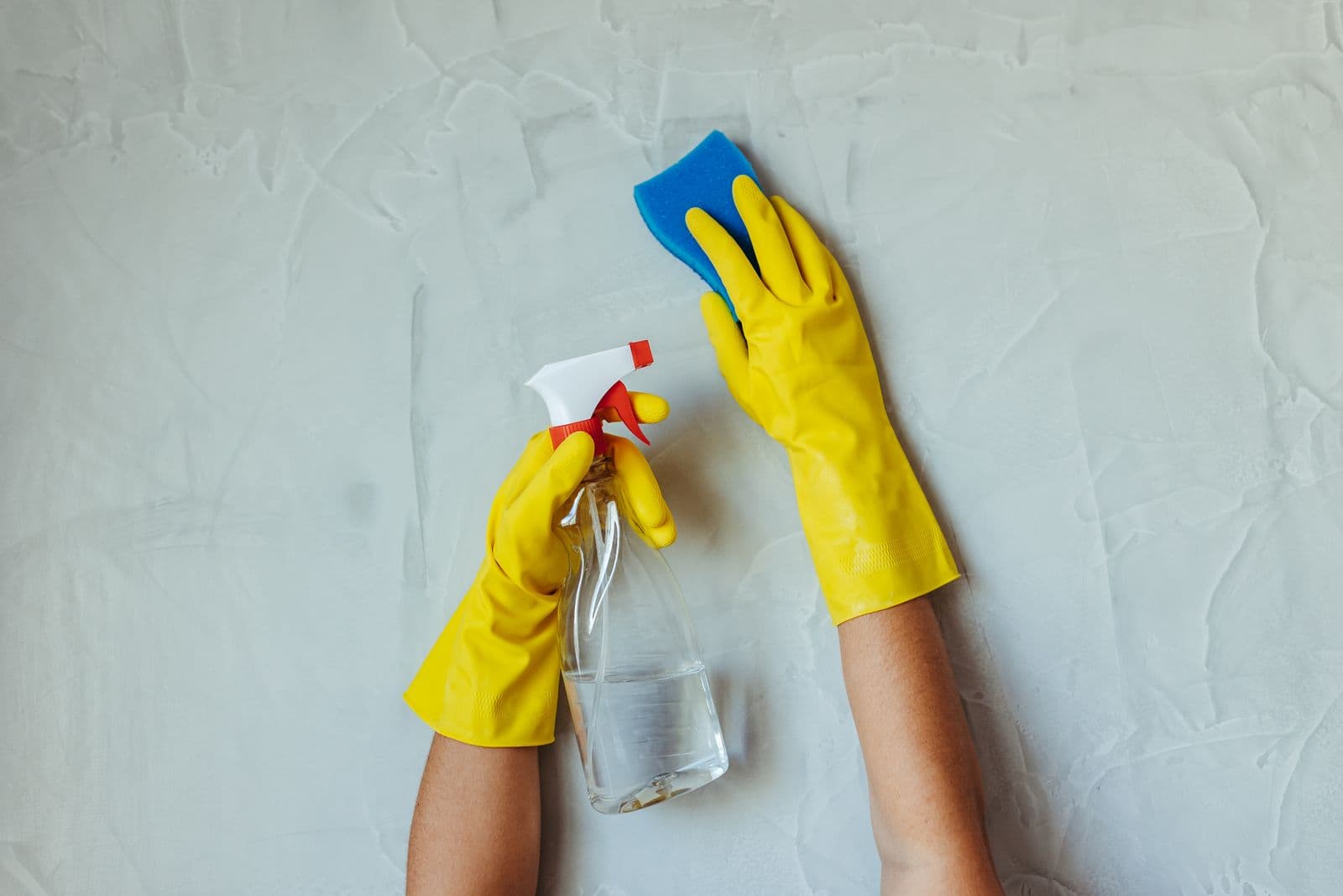 Lessivage d'un mur à l'éponge, gants aux mains