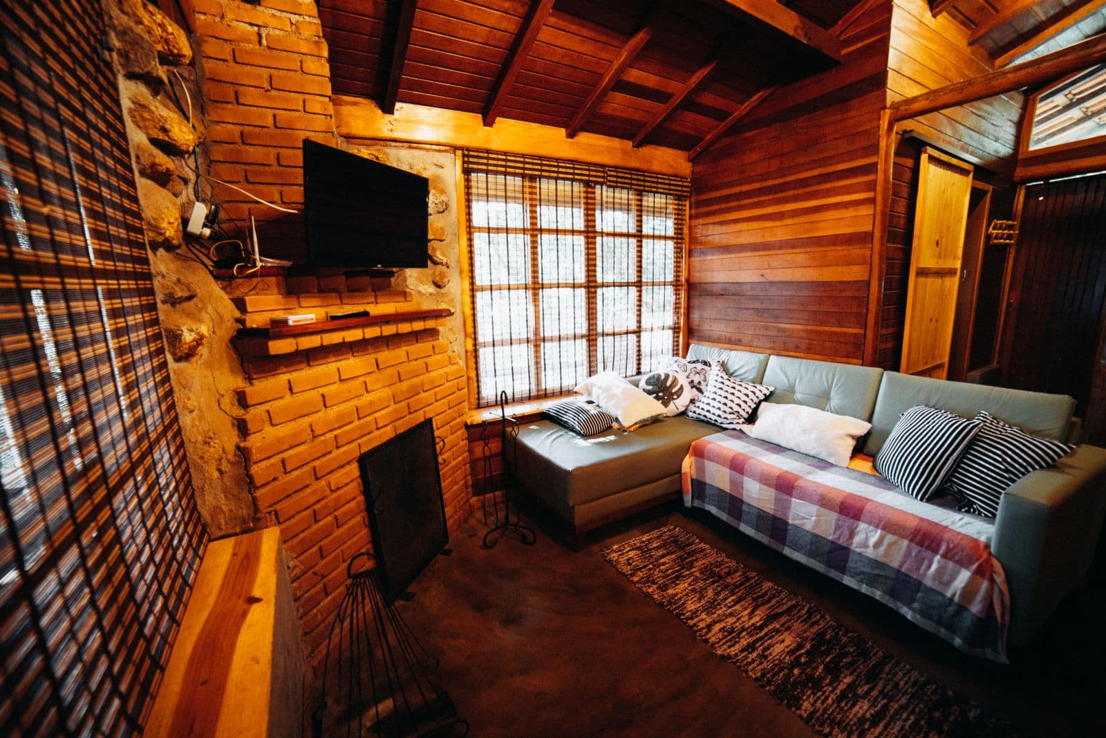 Séjour d'un chalet lambrissé, canapé et plaids